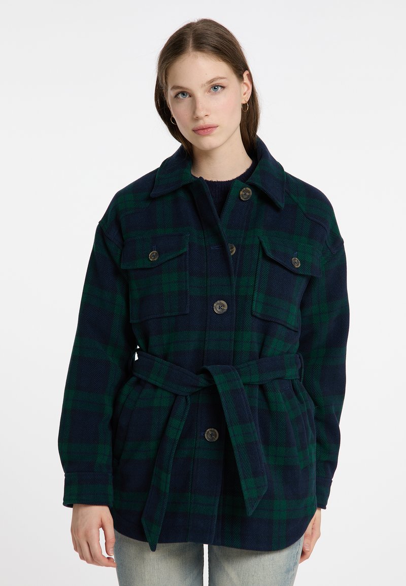 Giacca a scacchi in verde scuro e blu marino, con due tasche sul petto, chiusura con bottoni, colletto ampio e una cintura coordinata in vita.