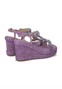 Sandali con zeppa in suede lavanda, con base in corda intrecciata e dettagli gioiello sulle cinghie. Fibbia regolabile alla caviglia per una vestibilità perfetta.