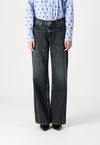 Wide-leg black denim jeans with a high waist, featuring coarse texture and slight fading. Paired with a blue button-up shirt.