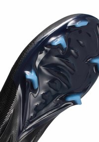 Suela de zapato deportivo negra con acentos azules, que presenta una superficie lisa y texturizada y múltiples tacos para tracción.