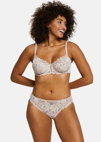 Ensemble assorti de soutien-gorge et slip en beige clair, avec des motifs floraux, des bords festonnés et des bretelles réglables. Texture douce avec des détails raffinés.