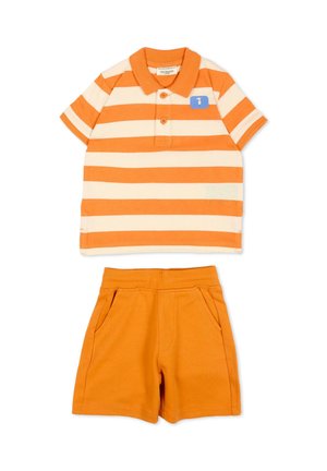 Pomarańczowa i kremowa koszulka polo w paski z krótkim rękawem i dwoma guzikami, połączona z jednolitymi pomarańczowymi szortami z elastycznym pasem i kieszeniami po bokach.