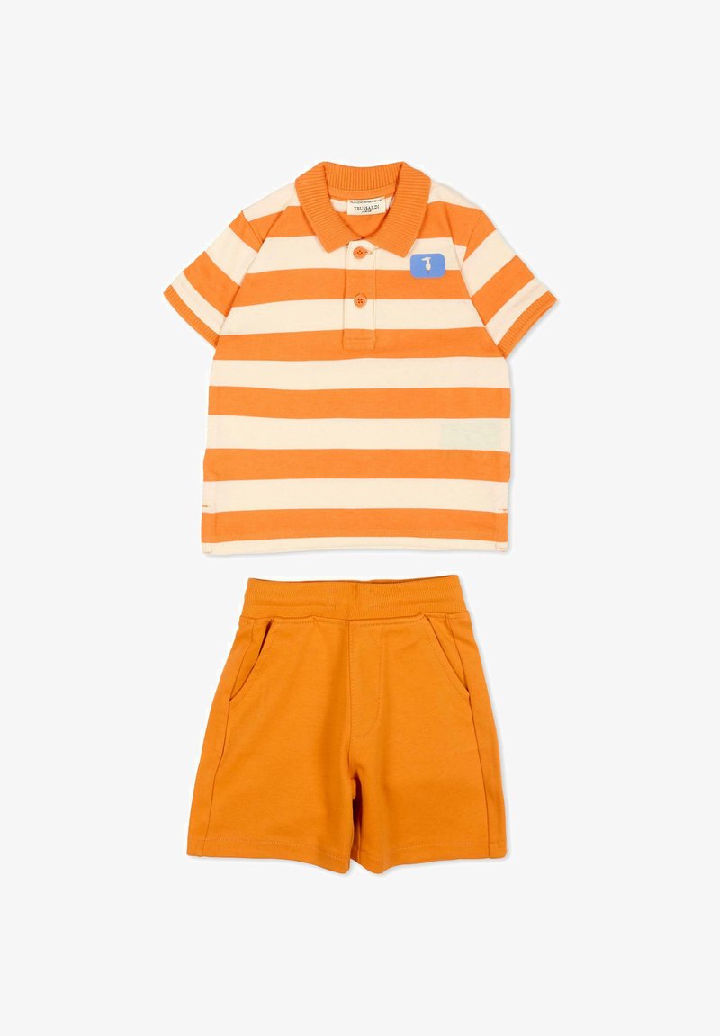 Polo à manches courtes rayé orange et crème avec deux boutons, associé à un short orange uni à taille élastique avec poches latérales.