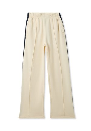 Pantaloni color crema con una texture morbida, dotati di tasche laterali e dettagli neri lungo le cuciture esterne. Vita elastica per il massimo comfort.
