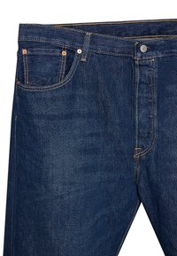 Vaqueros de mezclilla azul oscuro con costuras naranjas, cinco bolsillos, remaches de cobre y cierre de botón. Presenta un diseño de pierna recta.