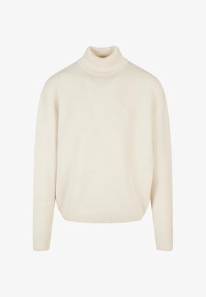 Kreemikaalune kõrge kaelusega sviiter, mis on valmistatud pehmest, tekstuurist kootud kangast; omab lõdva siluetti ja soonikkoes varrukaid. Ilma mustrite ja kaunistusteta.