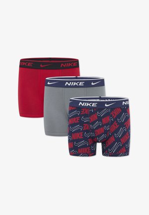 Trzy pary męskich bokserek: czerwone z czarną gumą, szare z granatową gumą oraz granatowe z powtarzającym się białym i czerwonym logo "Nike".