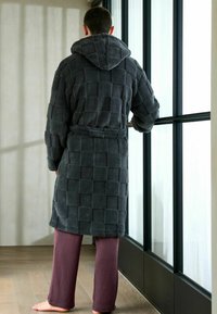 Grå texturerad badrock med huva, som har ett rutmönster och ett knyt i midjan. Kombinerad med ribbade burgundy byxor.