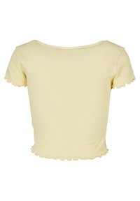 Haut court à manches courtes côtelé de couleur jaune clair avec des bords festonnés en forme de laitue aux manches et au bas, vu de dos.