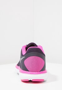 Scarpe sportive con tomaia in rete viola scuro e dettagli rosa, suola bianca. Presenti pannelli testurizzati e particolari riflettenti.