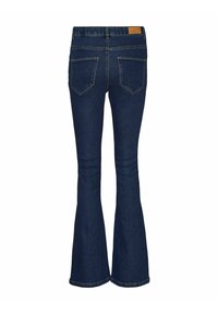 Ciemnoniebieskie dżinsy w fasonie dzwonów z dwoma tylnymi kieszeniami i brązową skórzaną metką na pasku, pokazane od tyłu.