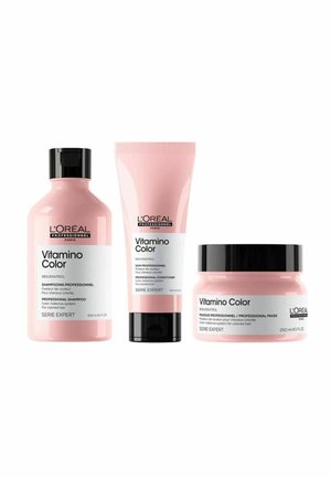 Three hair care products from L'Oréal Professionnel's Vitamino Color line. Pink bottles and tubes with black accents label various professional formulas.