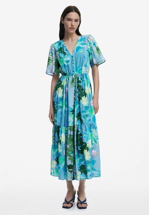 Blue floral maxi dress with short sleeves, a v-neckline, gathered waist, tiered skirt, and vibrant green and pink plant patterns.