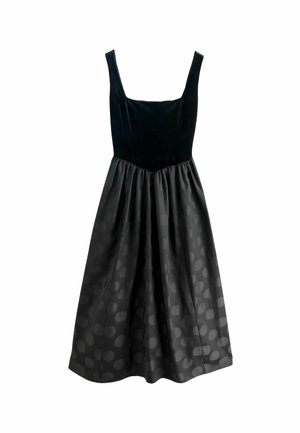 Black dress with a velvet bodice and a pleated satin skirt featuring a dark polka dot pattern. Square neckline and wide straps.
