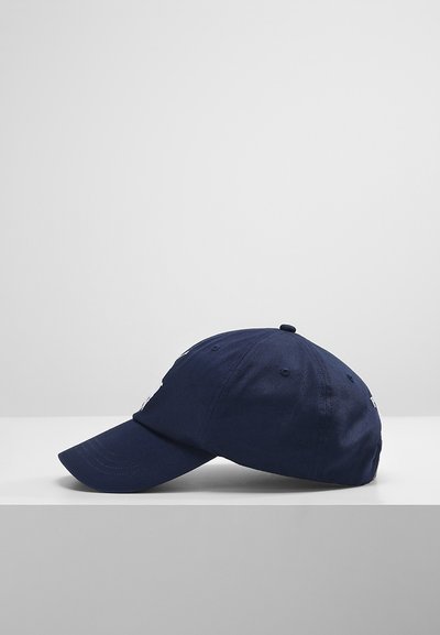 Ναυτικό μπλε καπέλο από βαμβάκι, με καμπύλη γείσο, έξι πάνελ και κεντητό λογότυπο στο μπροστινό μέρος. Η υφή φαίνεται ομαλή.