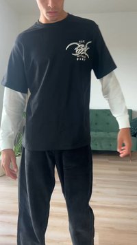 Must Black T-särk valge pika varrukaga särgi peal, koos mustade puuvillaste pükste ja teksadega. Omab esiküljel logo ja tekstuurset kangast.