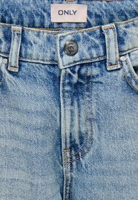Lyseblå denimjeans med høy midje, utstyrt med lukking med en sølvknapp, beltehemper og detaljer i kontrasterende søm. "ONLY"-merke synlig.