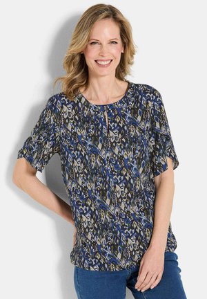 Luftige Bluse im Muster Blau, Grün und Beige; verfügt über kurze Ärmeln, einen runden Ausschnitt und ein dezentes Schlüssellochdetail an der Vorderseite.