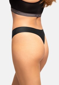 Zwarte bikini-ondergoed met een glad, minimalistisch ontwerp, voorzien van een brede tailleband en naadloze randen voor comfort en een strakke uitstraling.