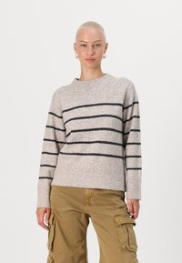 Beige knit sweater with black horizontal stripes, crew neckline, ribbed cuffs, and waistband. Worn with tan cargo pants.