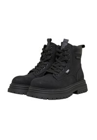 Bottes courtes noires en daim, présentant un design à lacets, des semelles en caoutchouc à profil épais, et une languette pour un enfilage facile.