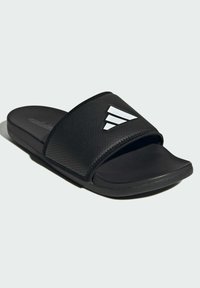 Black slide sandals with a textured strap featuring a white three-stripe logo. The footbed is contoured, providing comfort and support.