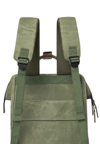 Zaino verde con spallacci imbottiti, materiale testurizzato, molteplici cinghie e una maniglia posteriore; presenta un design robusto e resistente.