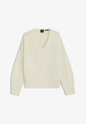 Krämfärgad stickad tröja med V-hals, nedfallna axlar och ribbade muddarna. Har dekorativ sömnad och en avslappnad silhuett.