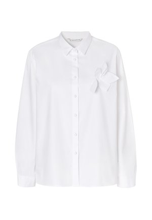 Biela košeľa s gombíkmi vyrobená z hladkej tkaniny, s špicatým golierom, dlhými rukávmi a ozdobným kvetom z látky na ľavej strane.