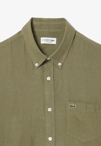Olivengroene knoopshirt in een linnenmix met een regular fit, voorzien van een klein geborduurd krokodillenlogo op de borstzak.