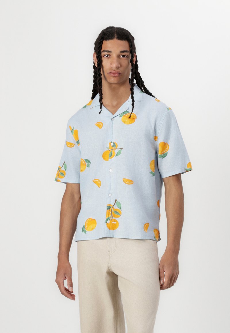 Camicia azzurra a maniche corte con bottoni, caratterizzata da una vivace stampa arancione e foglie, realizzata in tessuto leggero con una vestibilità comoda.