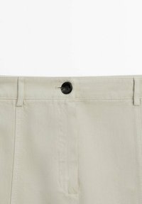 Beige katoenen broeken met een gladde textuur, voorzien van een knoopsluiting en twee voorzakken, ontworpen voor een goede pasvorm.