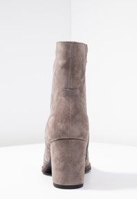 Szare zamszowe botki do kostek na słupku, z gładką teksturą i prostym wzornictwem; widok z tyłu podkreśla obcas i kontur.