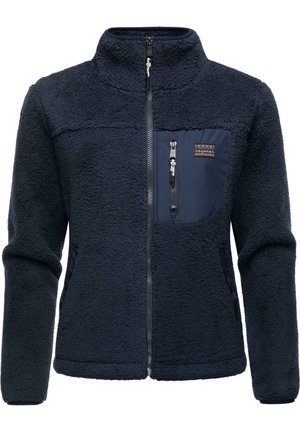 Veste en polaire marine avec un extérieur texturé, un col haut, une fermeture éclair sur le devant et une poche poitrine zippée avec une couture colorée.