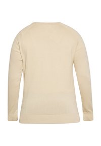 Beige hosszúujjú pulóver sima textúrával, kereknyakkivágással, bordás mandzsettákkal és alsó résszel. Rágolniós ujjaival és egyszerű dizájnjával rendelkezik.