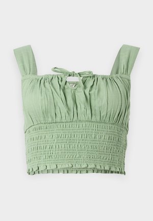 Hele rohelise tooni crop top, millel on smockitud tekstuur, laiad rihmad ja kinnitatav kaelus. Omab volditud kangast, mis tagab mugava istuvuse.