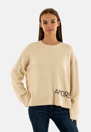Pull en maille beige avec ourlet côtelé, manches larges et "AMORE" brodé en fil sombre sur le devant. Texture douce et coupe décontractée.