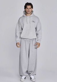 Grauer Hoodie und passende Jogginghose aus Baumwollmischgewebe. Der Hoodie verfügt über eine Fronttasche und ein Logo; die Hose ist locker geschnitten mit elastischem Bund.