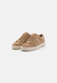 Tanfarbene Wildledersneaker mit Netzpaneelen, runder Zehenpartie, beige Gummisohle und goldenen Hardware-Details mit dem Markennamen an der Seite.
