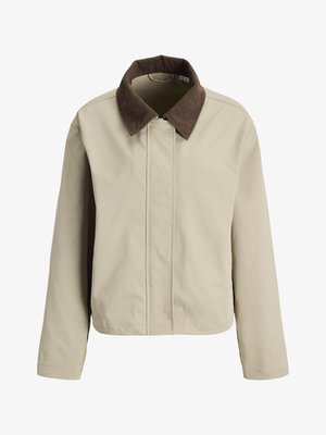 Beige jakke med glidelås foran og knappestenging, med en kontrasterende brun kordfløyelskrage og lange ermer.