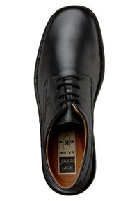 Zapato negro de cuero con cordones, de textura suave, punta redonda y plantilla marrón en contraste. Presenta un borde cosido y un logotipo en la plantilla.