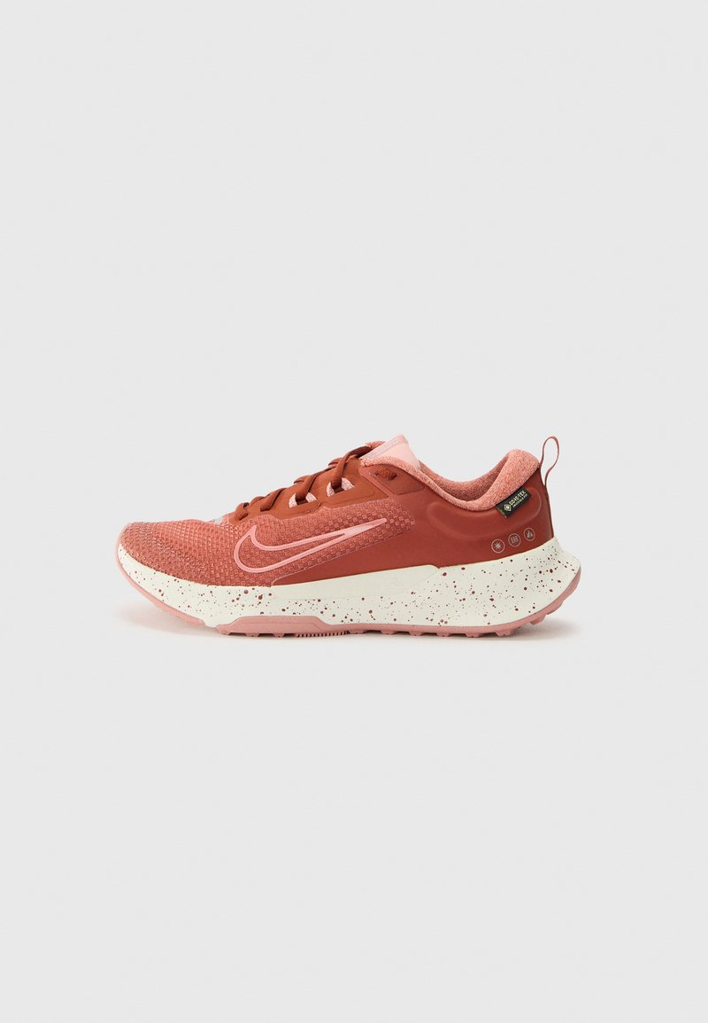 Nike sneakers met een ademende rode mesh bovenkant, roze accenten, gespikkelde crèmekleurige tussenzool en een gestructureerde rubberen buitenzool.
