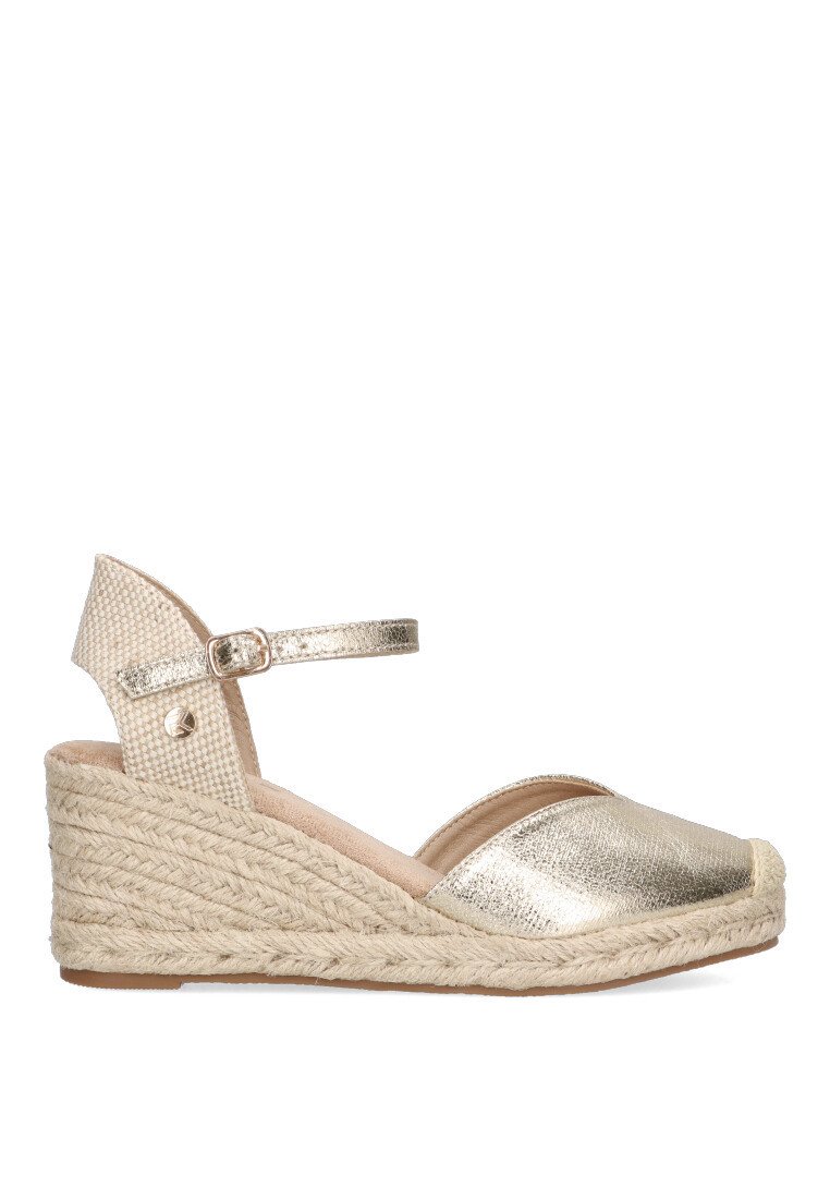 Sandalia de cuña de espadrille en metal dorado con suela de yute trenzado, tiras ajustables en el tobillo y parte superior de tela con un acabado texturizado.