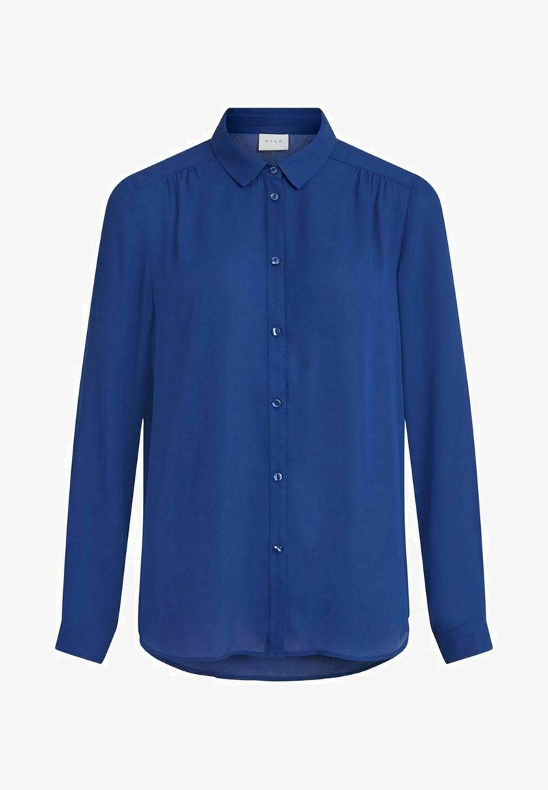 Blouse bleu roi à manches longues, boutonnée, avec col et fronces subtiles aux épaules, présentée sur fond blanc.