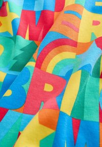 Värikäs kangas, jossa on rohkeita, päällekkäisiä kirjaimia ja muotoja kirkkaanpunaisena, sinisenä, vihreänä, keltaisena ja oranssina. Sileä pinta.