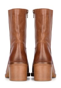 Botas de tobillo de cuero marrón con un acabado suave, que presentan una punta redondeada, cremalleras laterales y un tacón de madera apilada.