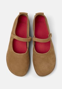 Scarpe Mary Jane in camoscio marrone con un cinturino e fodera rossa, viste dall'alto, che evidenziano il design e i dettagli dei colori.