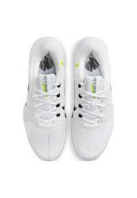 Des baskets blanches avec des accents noirs, une tige en mesh texturé, des lacets plats et une semelle rembourrée ; la marque est visible sur la semelle intérieure et sur le côté.