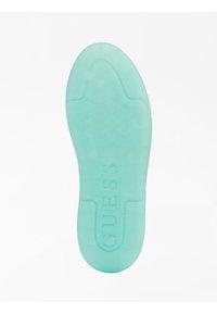 Przeźroczysta zielonkawo-miętowa gumowa podeszwa z teksturowanym wzorem zapewniającym przyczepność; na środku wytłoczone logo „GUESS”.