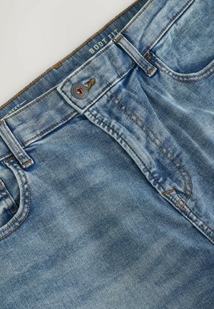 Jeans de mezclilla azul con un diseño de ajuste bota, con cierre de botones, costuras en contraste y una etiqueta en la cinturilla.